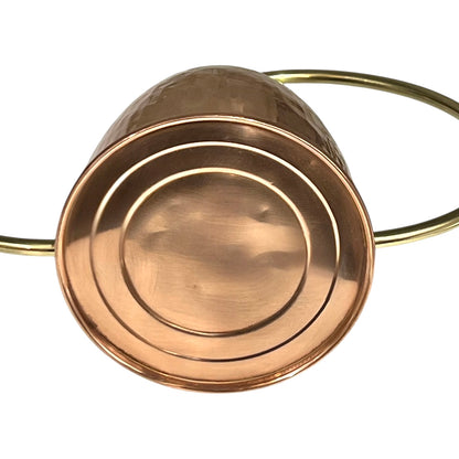 Close up of copper and brass watering can on a white background