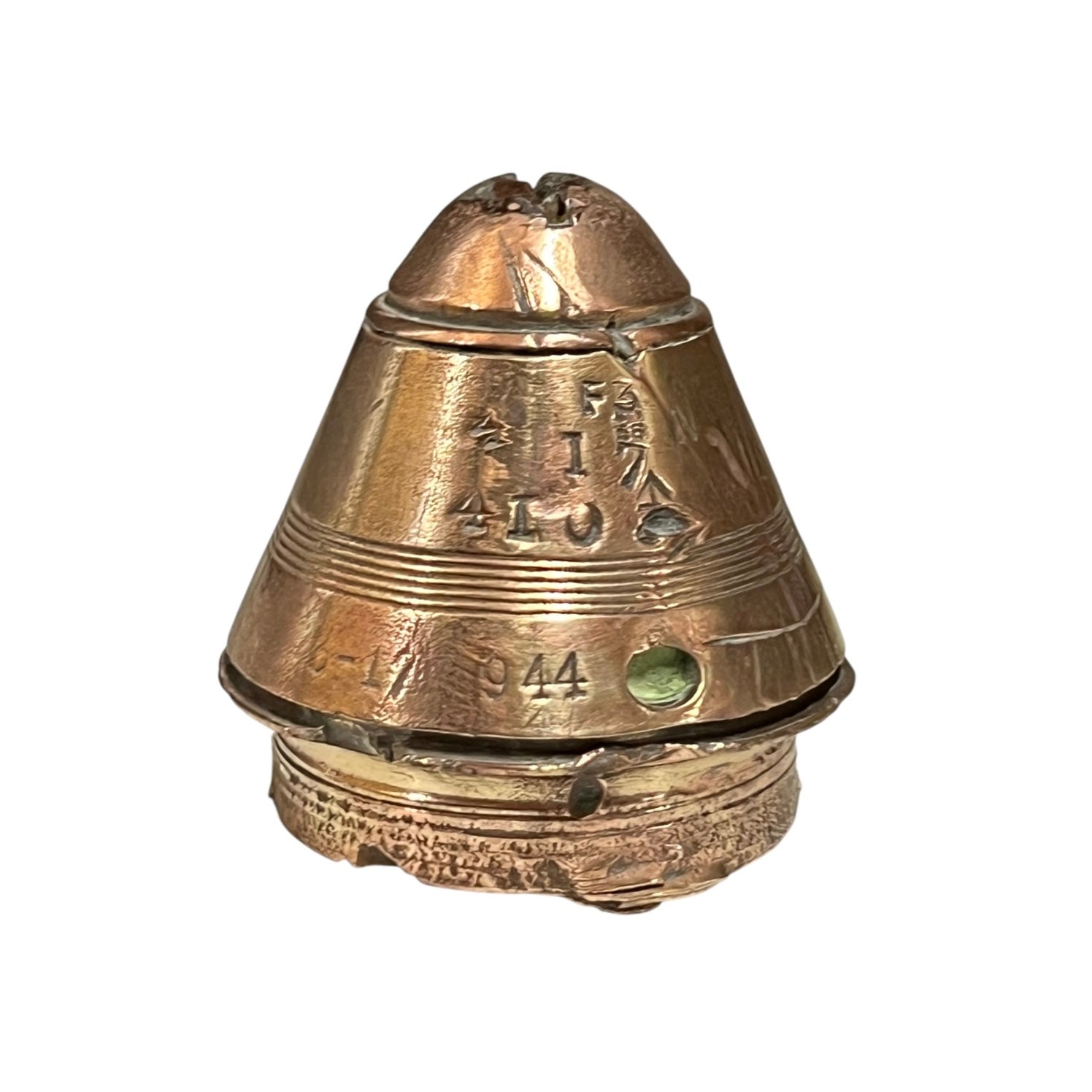 WW1 brass fuse paperweight with markings from use on a white background