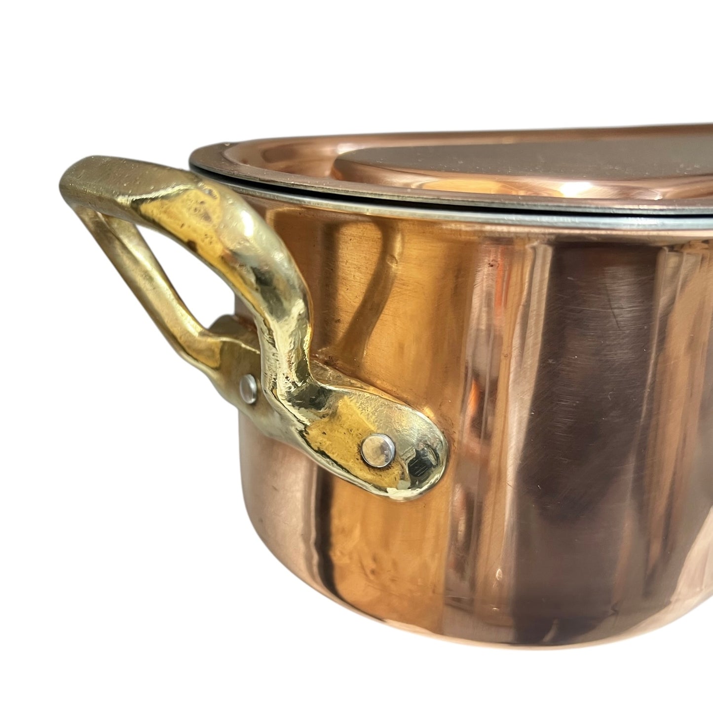 Close up of a copper French fish poaching pan with brass handles and an inner tray with lid on a white background