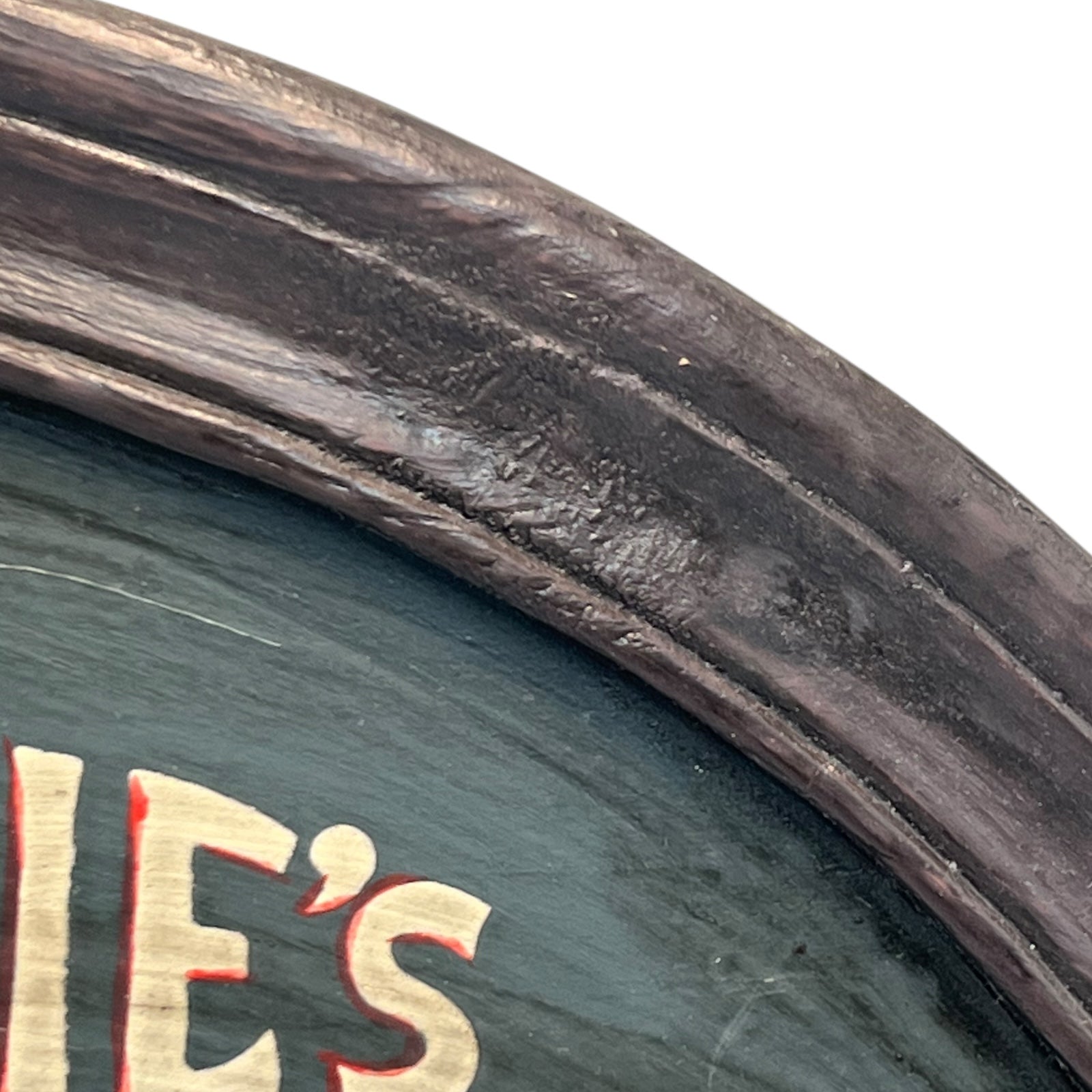 Corner of a framed picture with a dark brown frame and green interior.