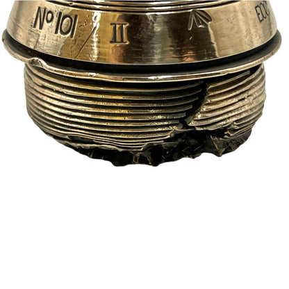 Close up of a polished British brass WW1 fuse or paperweight type 101 on a white background