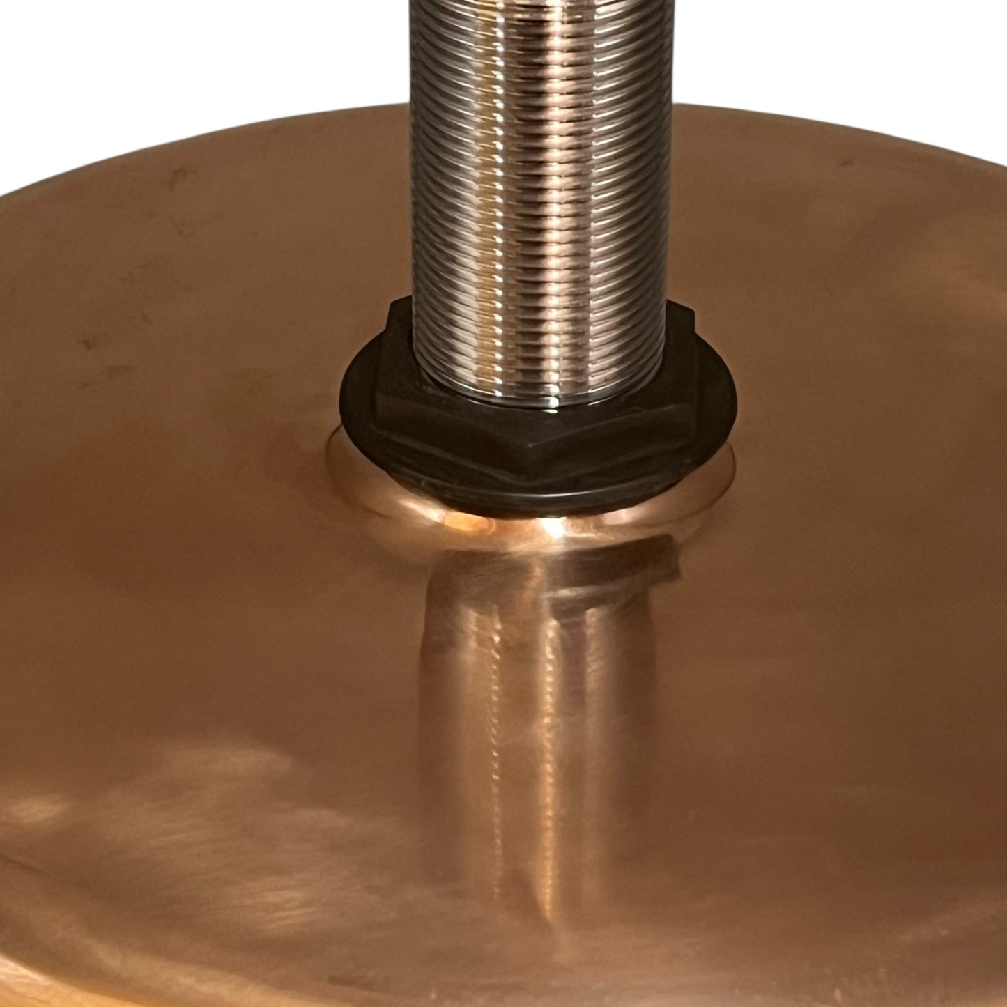 Close-up of a copper sink with a brass handle on a white background