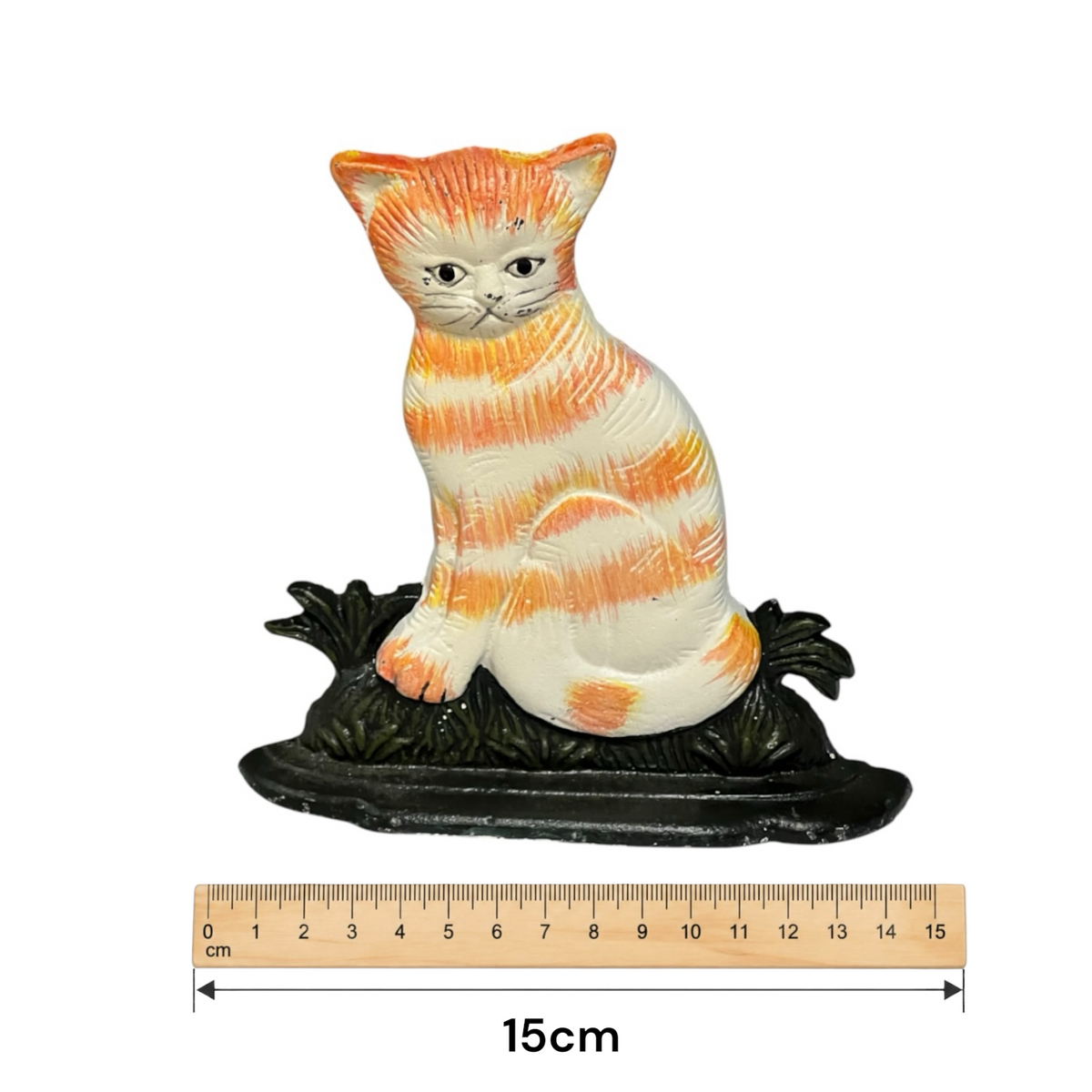 An orange and white striped cat door stop sitting on a dark base, shown with a 15cm ruler underneath for scale on a white background.