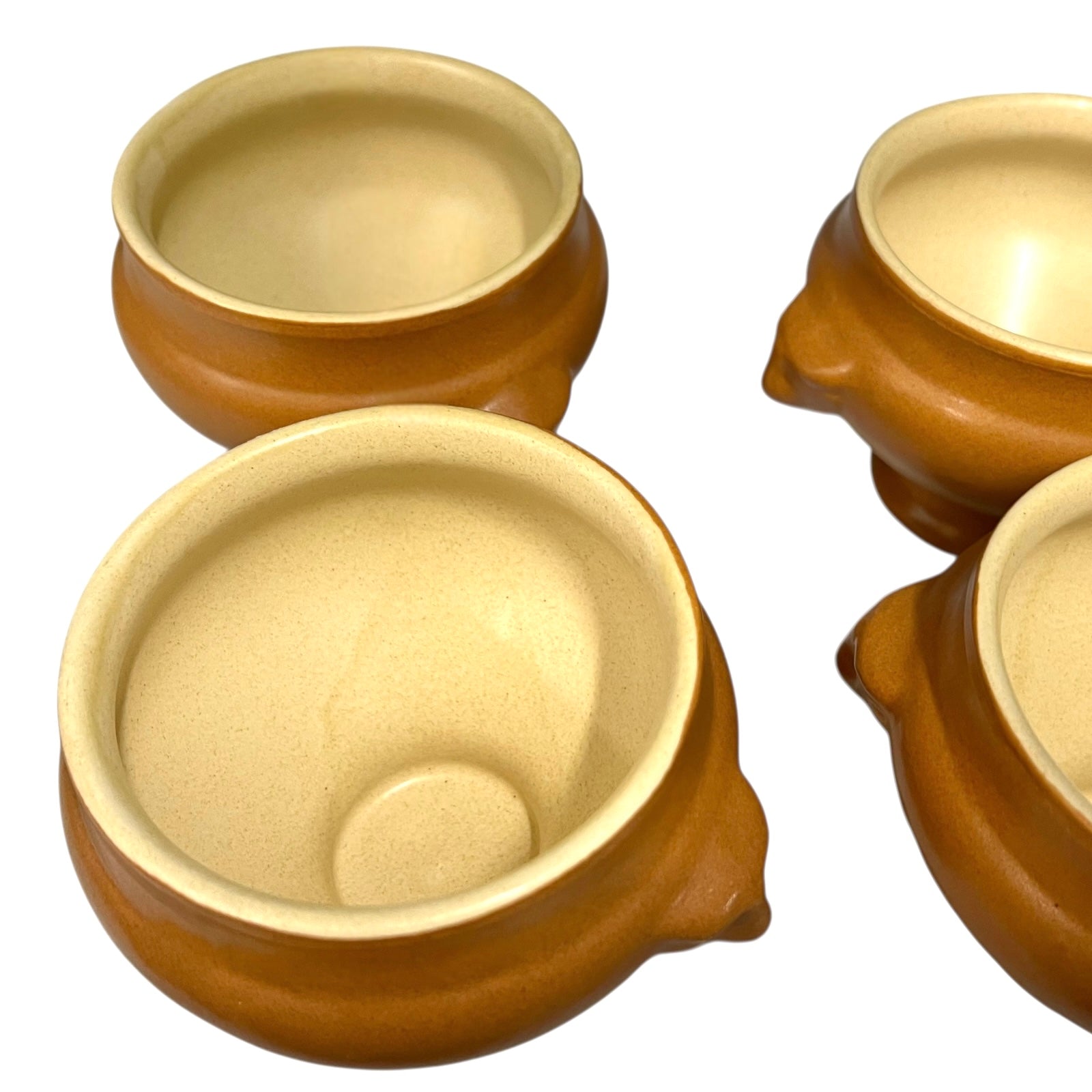 light brown ceramic French soup bowls with lions head handles on a white background 