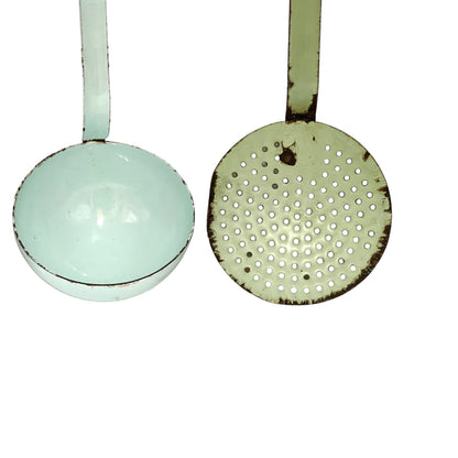 A pair of vintage enamel ladle strainers in a light mint green color, showing both the smooth bowl side and the perforated strainer side, set against a plain white background.