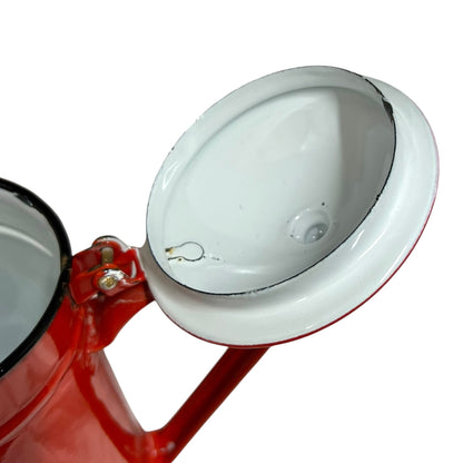 Close up of a red vintage French enamelled coffee pot on a white background