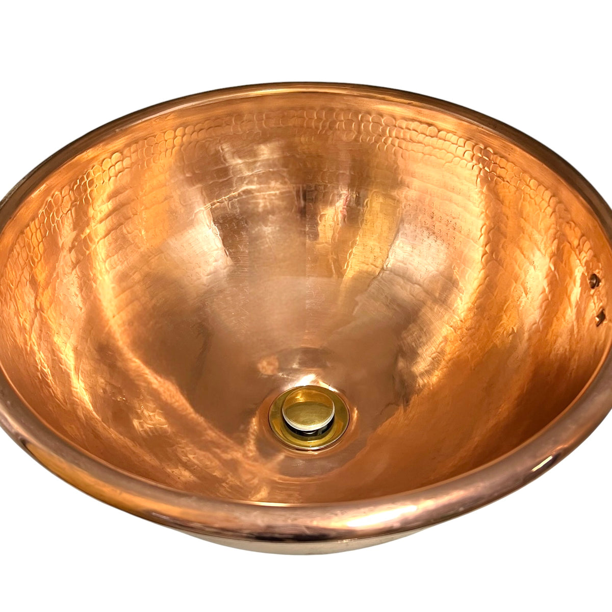 A hammered copper bathroom sink basin with a polished brass drain, shown from a top-down perspective against a white background.