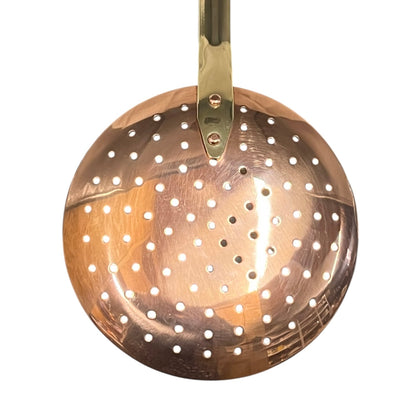 Copper skimmer with a gold handle on a white background