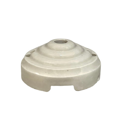 A small off-white ceramic or porcelain ceiling rose with a ribbed top and two side holes, shown on a plain white background.