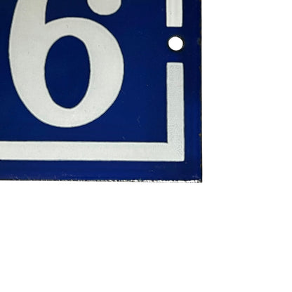 Close up of a French enamel door number on a white background 
