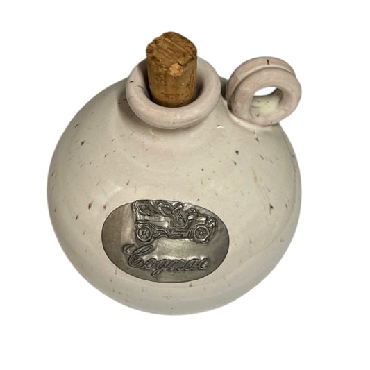 Round ceramic container with cork stopper and vintage car emblem on a white background