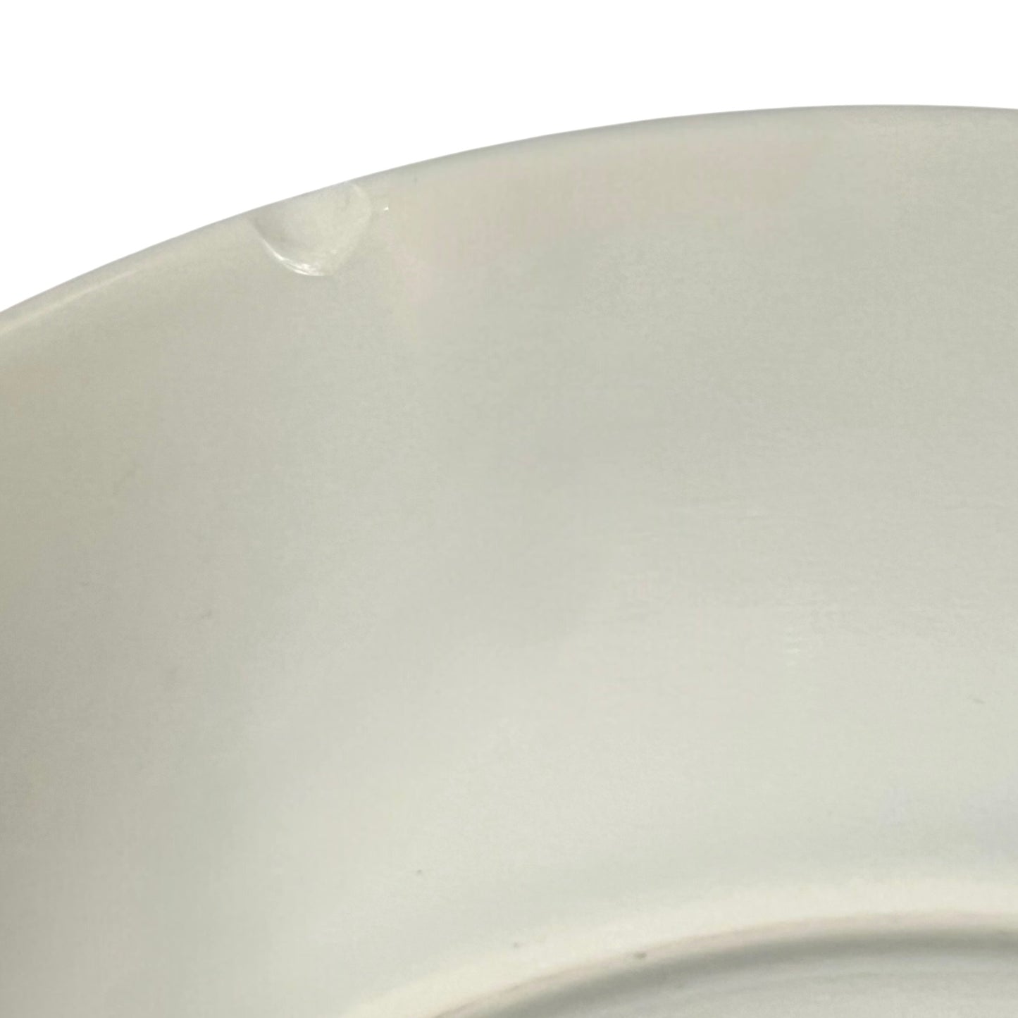 Close-up of a white ceramic plate with a subtle texture on a white background