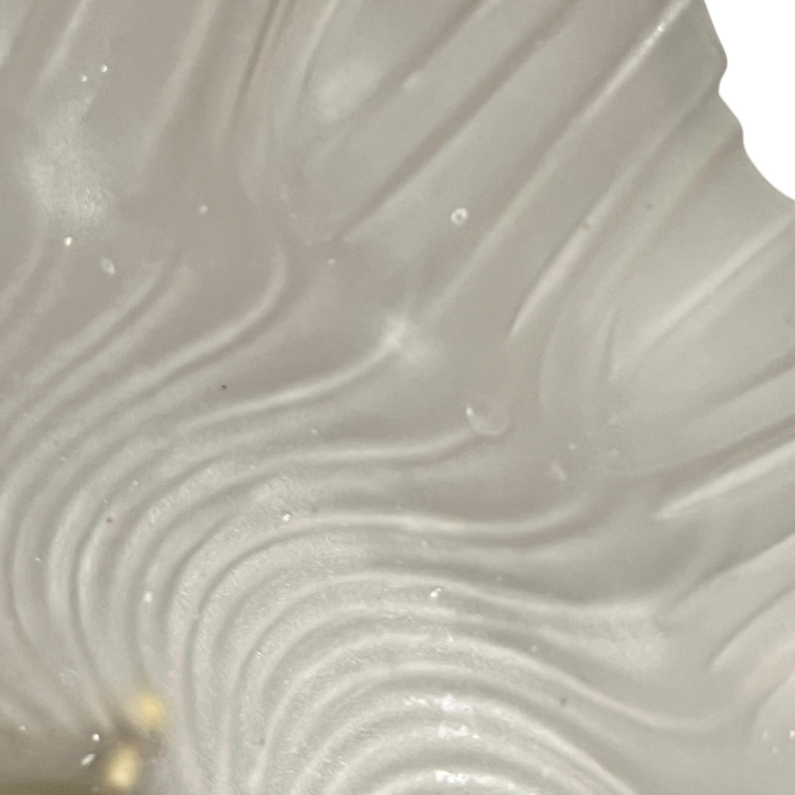 Close up of a glass lampshade and brass fittings on a white background