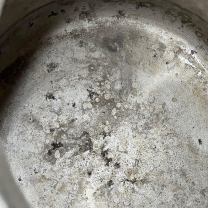 Close up of a vintage metal milk churn on a white background