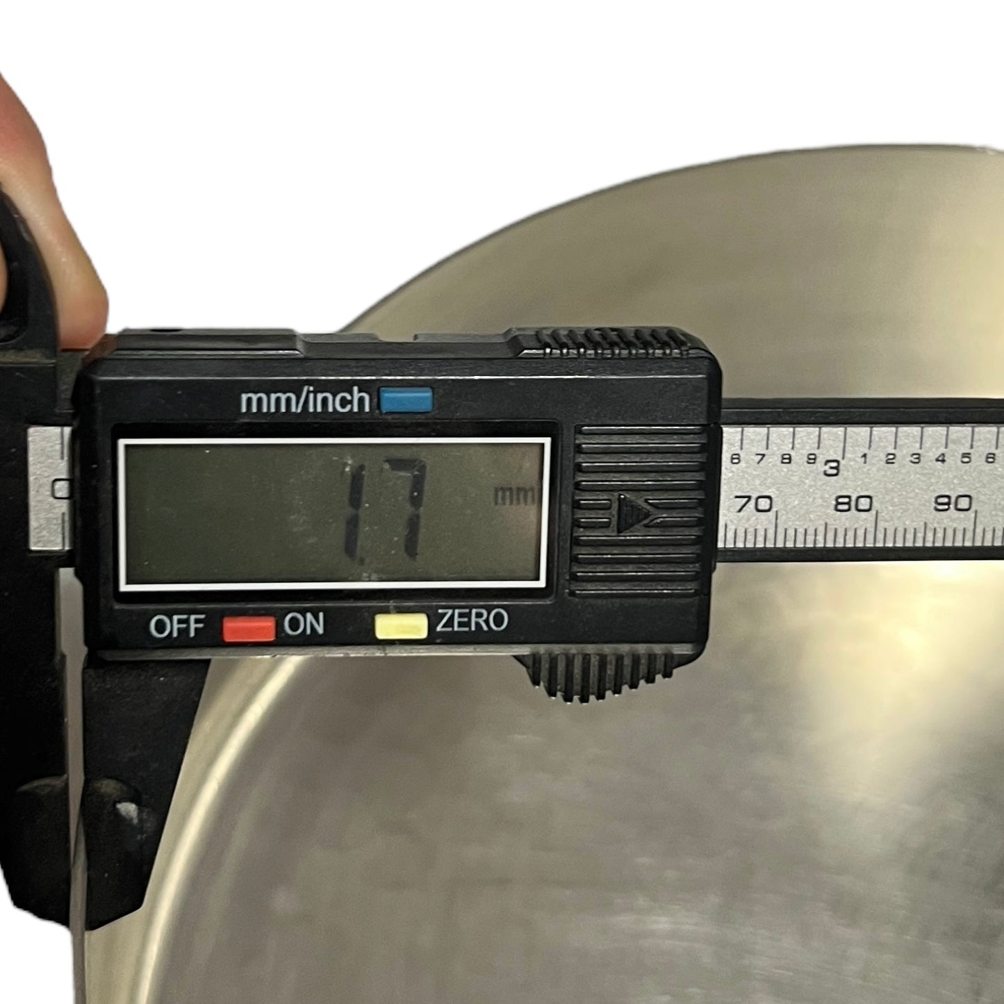 Digital caliper measuring a metal object with a digital display showing '1.7 mm'.