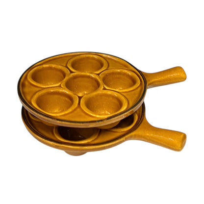 pair of amber-coloured French ceramic escargots plates with handles on a white background