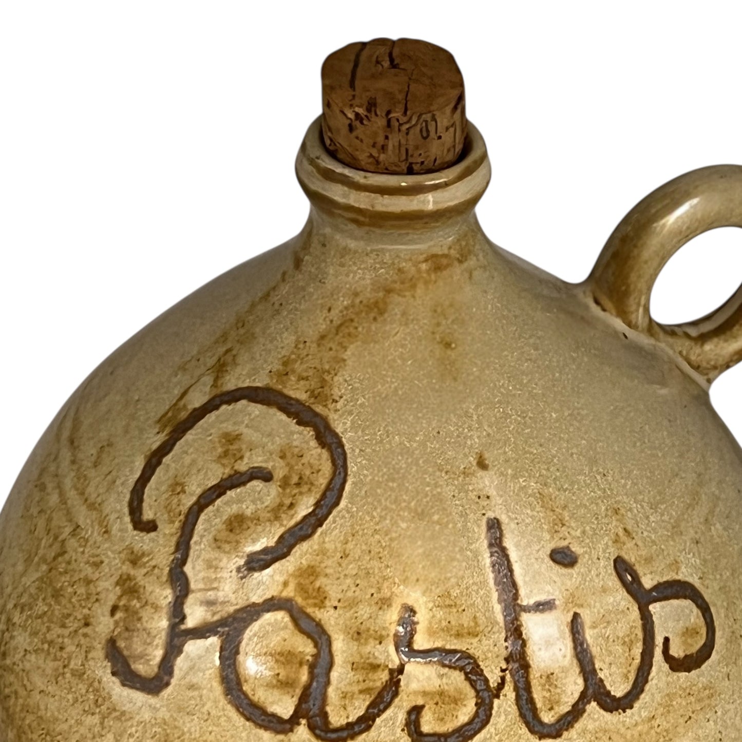 Vintage-style ceramic bottle with 'Pastis' engraving and cork stopper on a white background