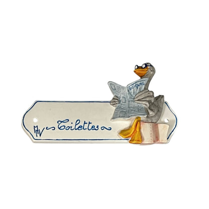 Decorative novelty door sign for a toilet labelled in French as Toilettes, with a goose reading a newspaper  decoration on a white background