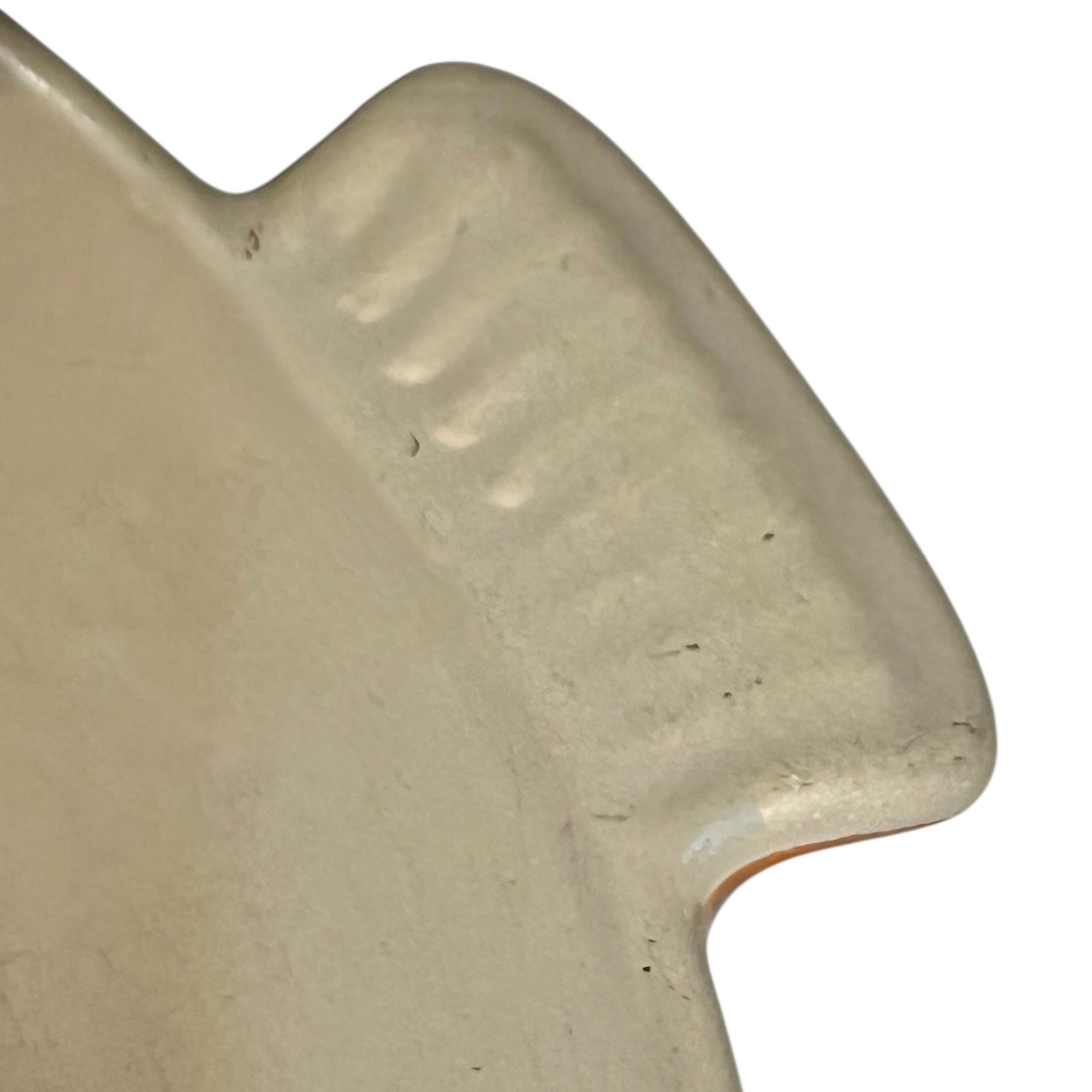 Close up of Le Creuset dish with beige interior on a white background