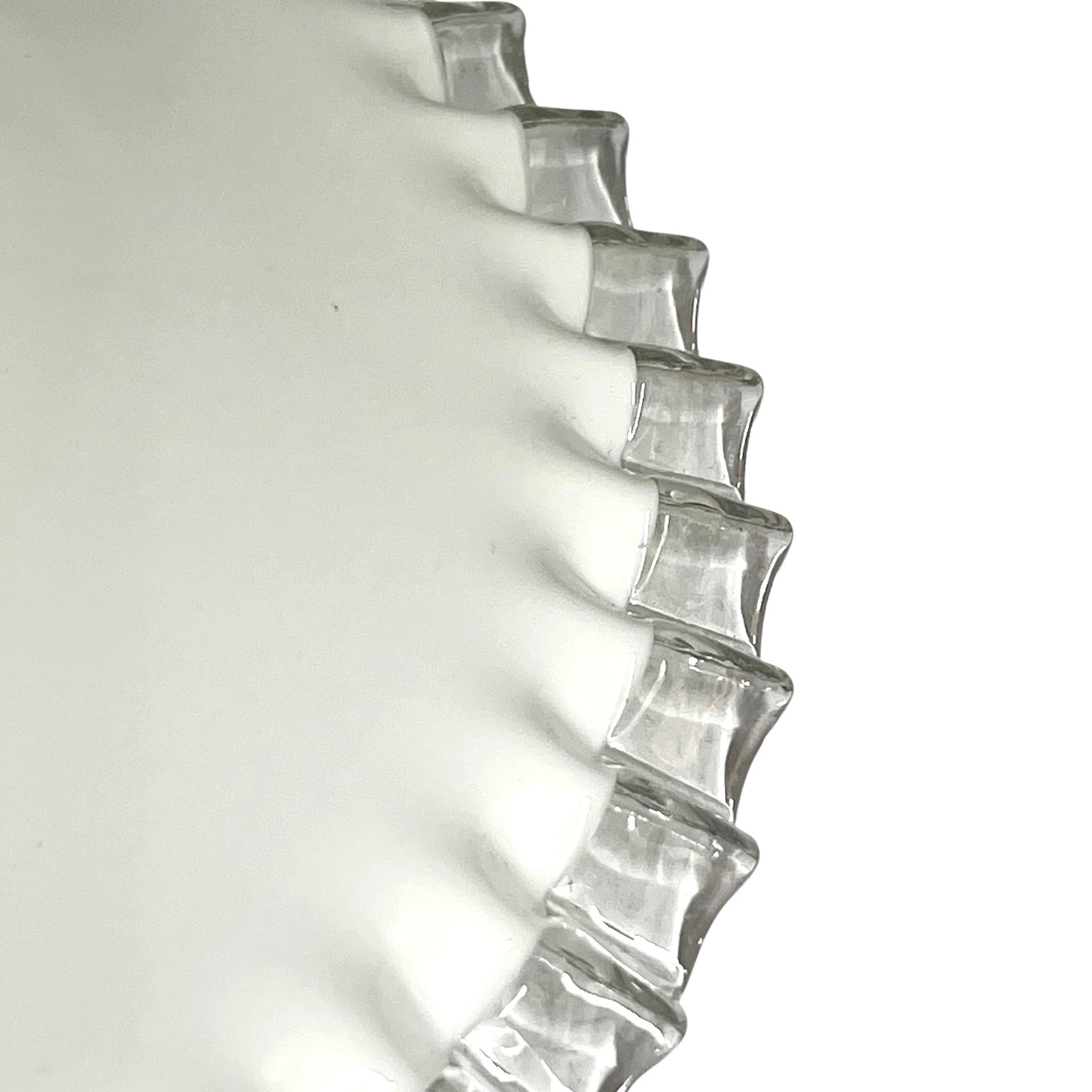 A close-up of a clear glass lampshade with a wavy, scalloped rim, photographed against a plain white background.
