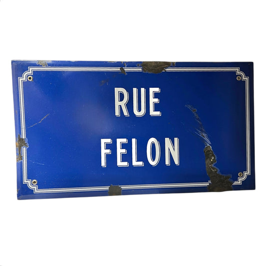 Blue street sign with 'RUE FELON' text on a white background