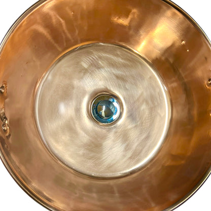 Close-up of a copper basin with a reflective finish on a white background 
