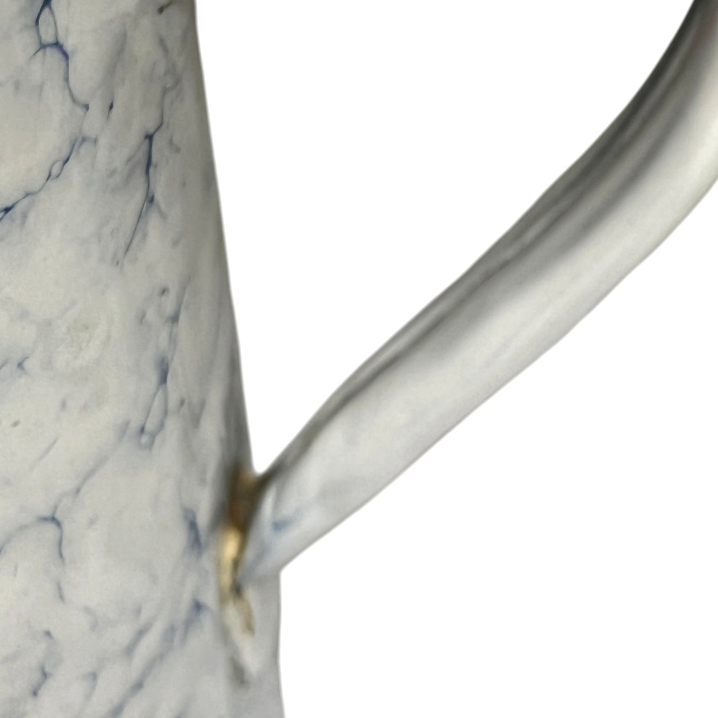 A close-up of a white pot with a marble-like blue veining pattern and a curved handle, isolated on a white background.