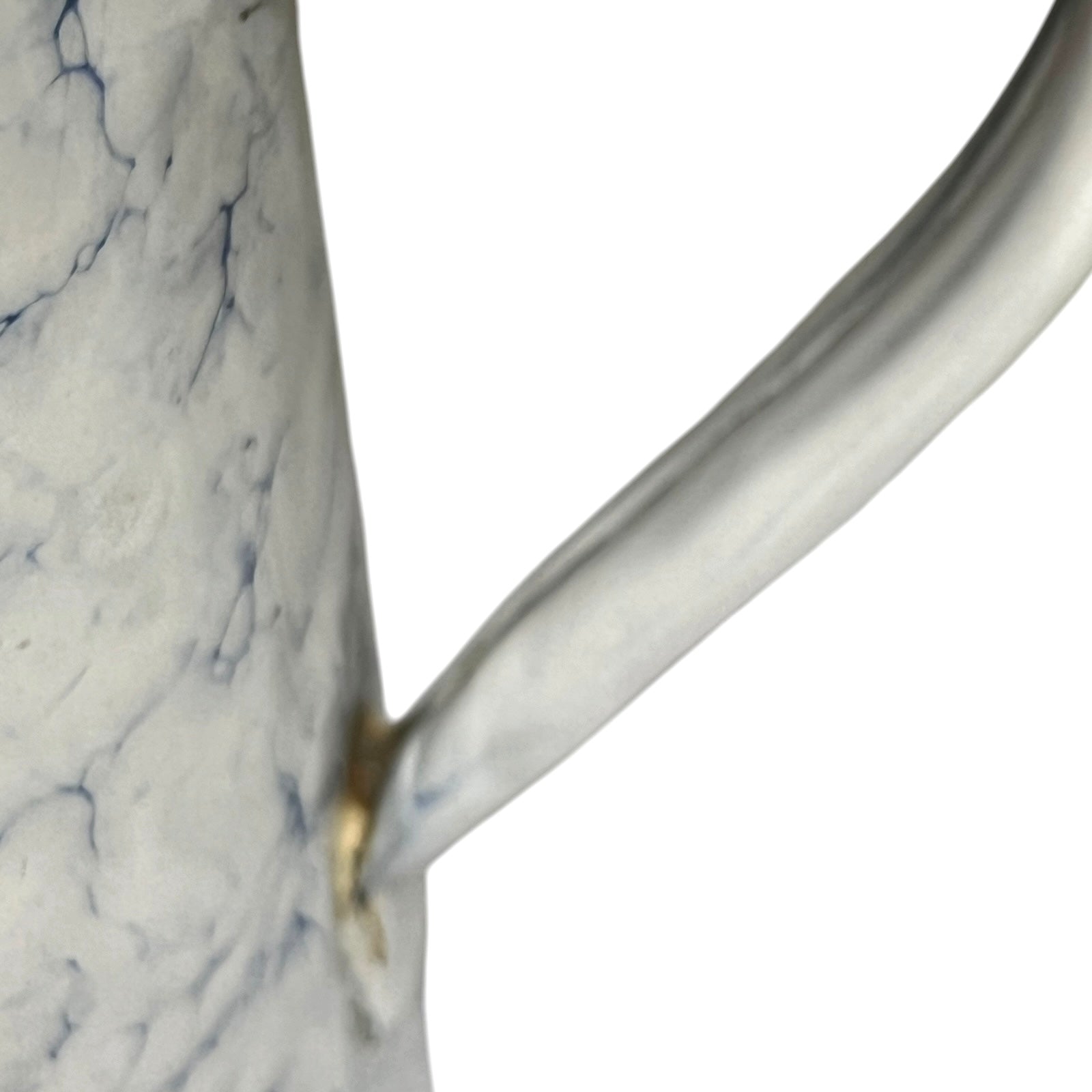 A close-up of a white pot with a marble-like blue veining pattern and a curved handle, isolated on a white background.