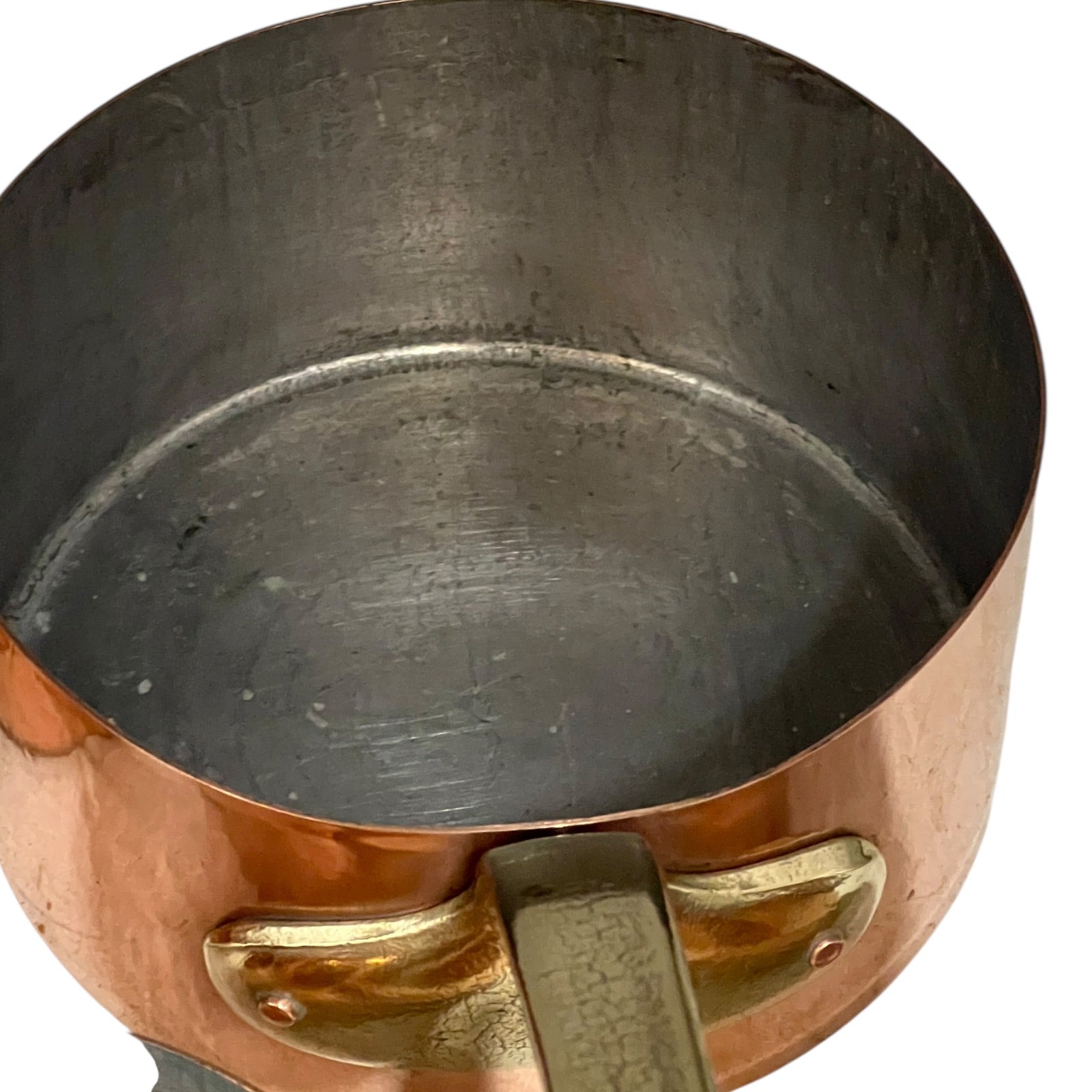 Close-up of a copper pot with a brass handle and tin lining on a white background