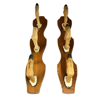 Two wooden wall hooks with deer hoof designs on a white background
