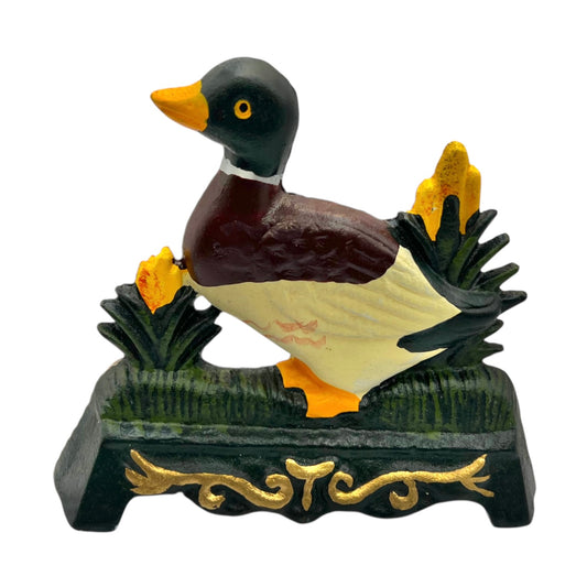 Cast iron duck doorstop on a decorative stand with a white background