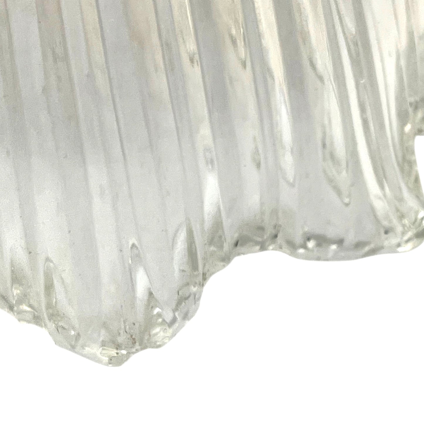 Close-up of a clear glass vase with ribbed texture on a white background