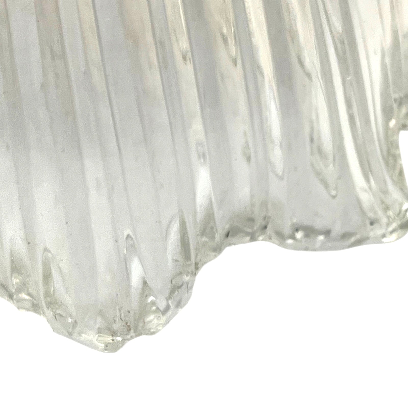 Close-up of a clear glass vase with ribbed texture on a white background