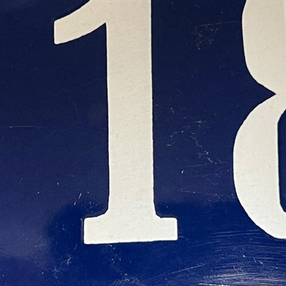 Close-up of a blue sign with white number 118 on a white background