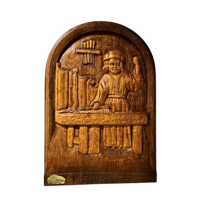 Wooden relief sculpture with a person and cross on a white background