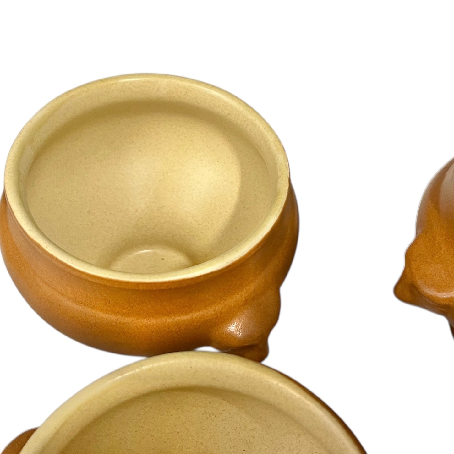 light brown ceramic French soup bowls with lions head handles on a white background 