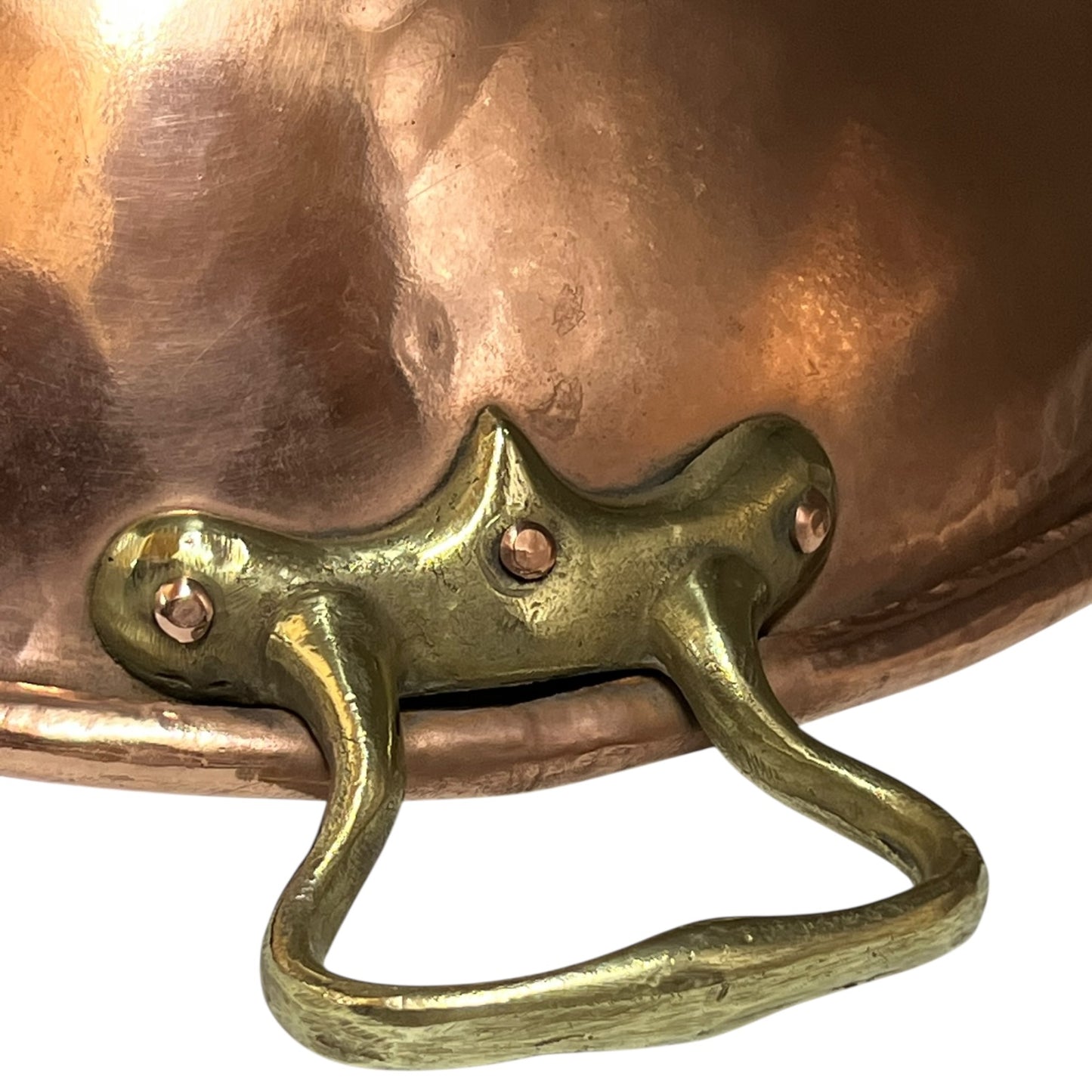 Close-up of a copper pot with a brass handle on a white background