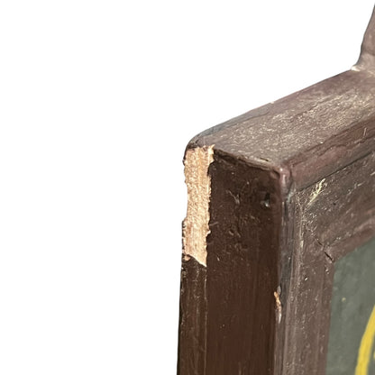 Corner of a framed picture with a dark brown frame and green interior.