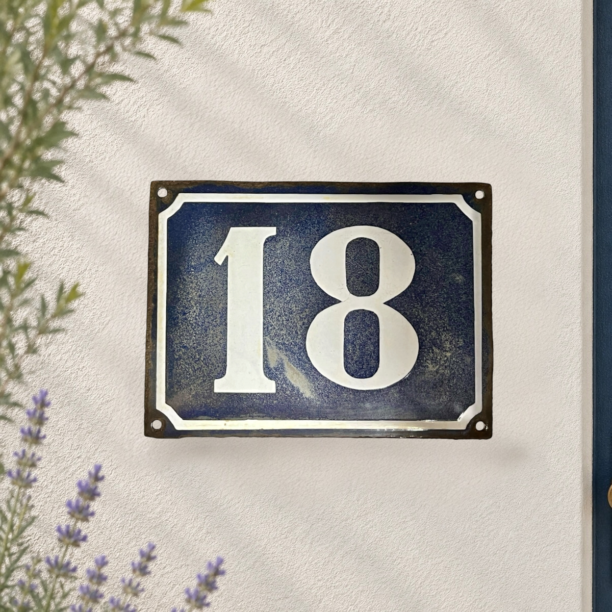French vintage enamel large door number 18 on a white washed wall 