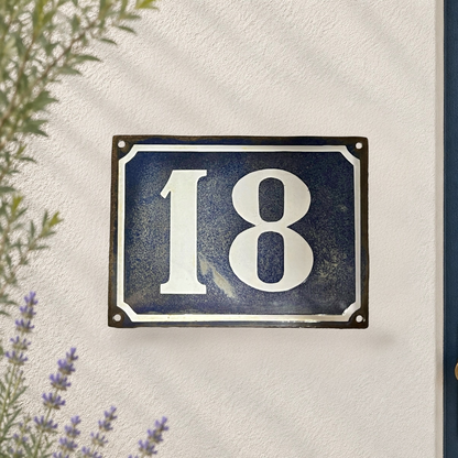 French vintage enamel large door number 18 on a white washed wall 