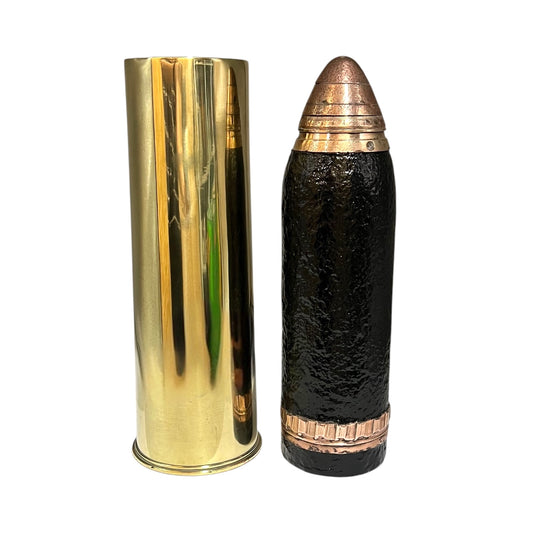 A WW1 18 pounder consisting of a brass shell, iron shrapnel and brass fuse on a white background 