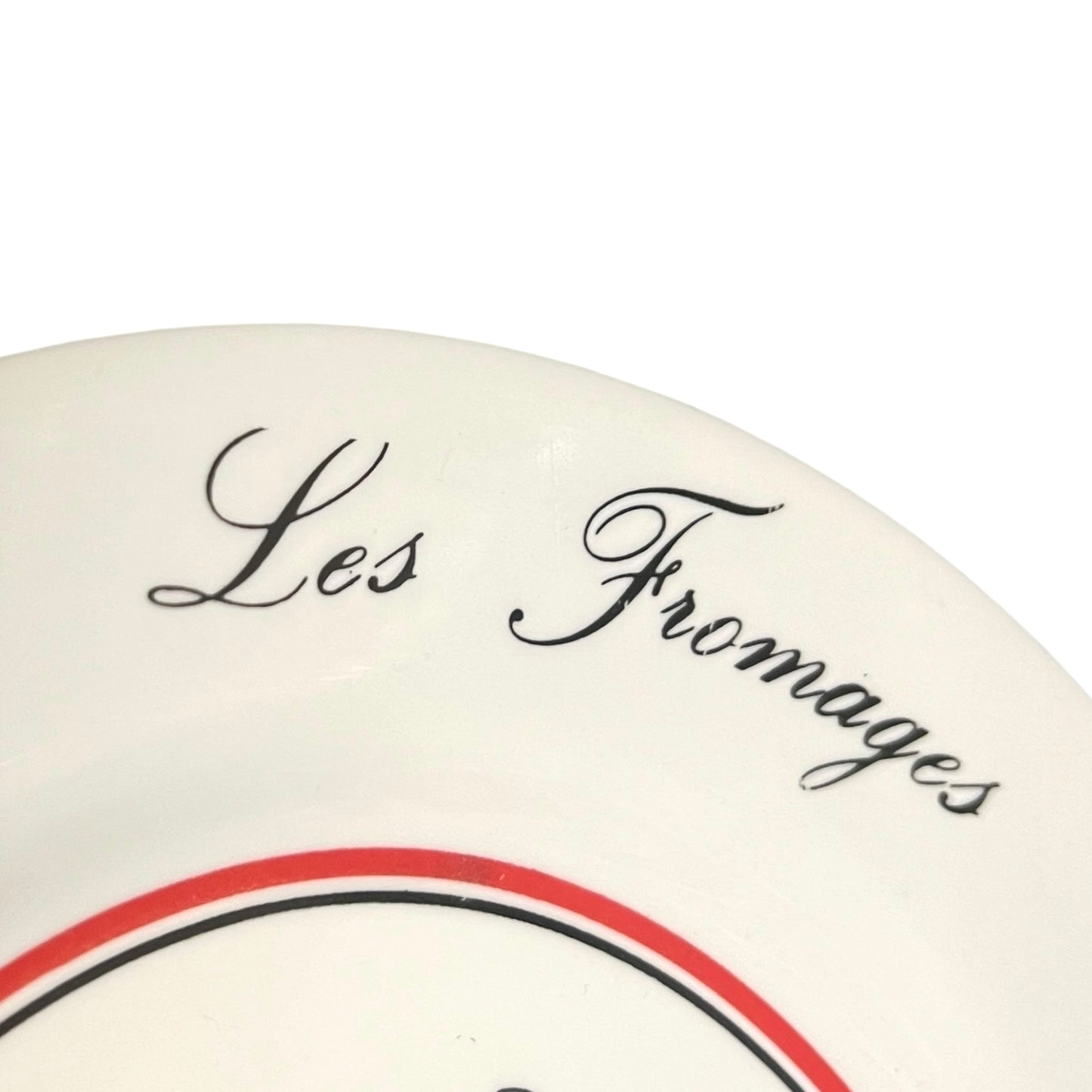 Round white plate with 'Les Fromages' text and red and black design on a white background