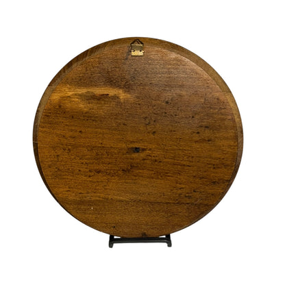 close up of a wooden decorative round plaque on a white background 