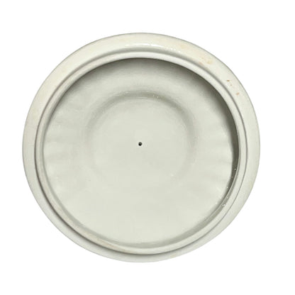 Round ceramic lid with a white glaze on a white background