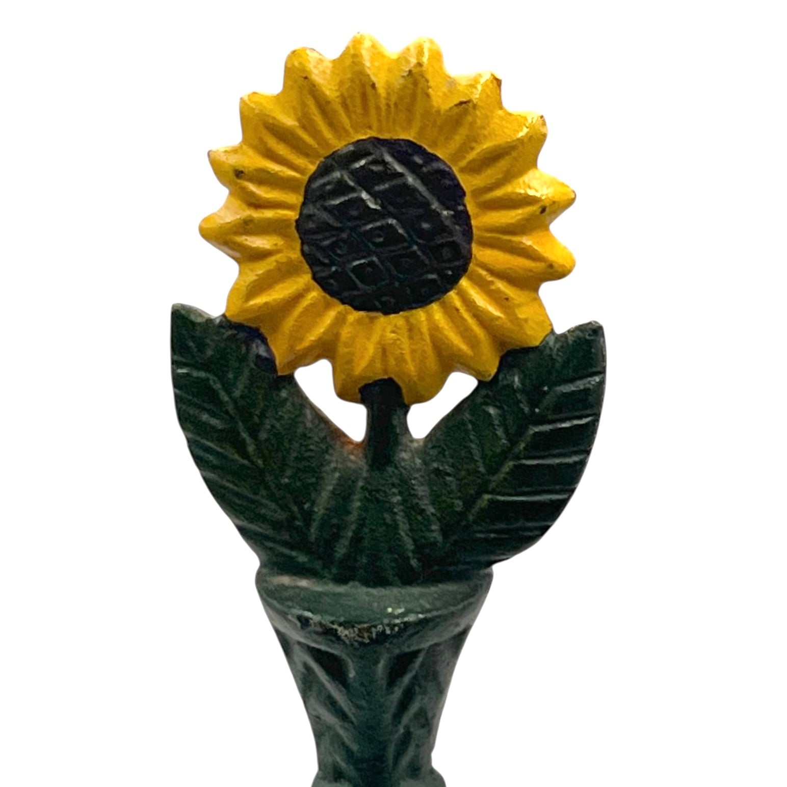 Decorative sunflower top with yellow petals and green leaves sitting on a kitchen roll holder on a white background