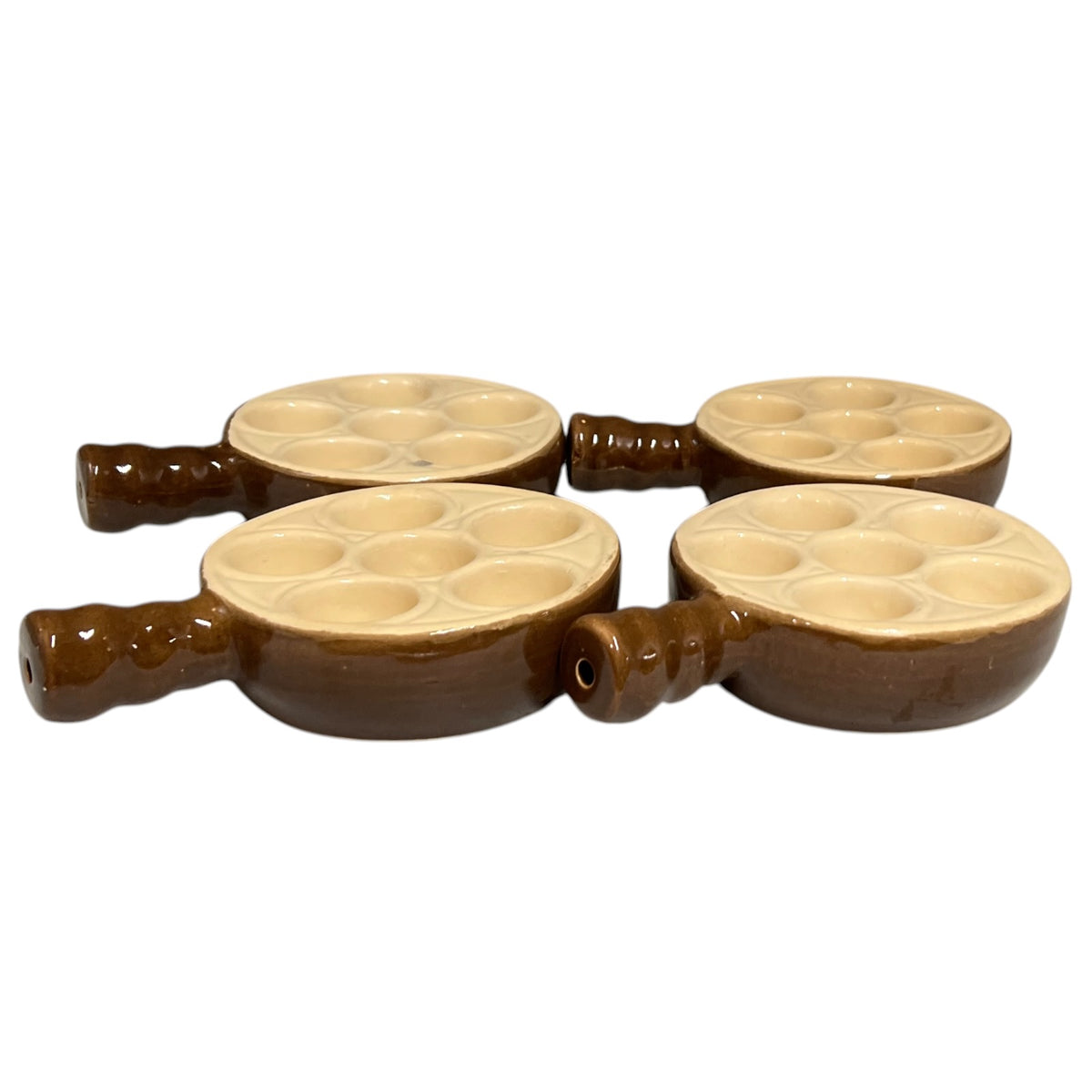 Four brown ceramic mini snail plates with beige interiors, arranged in a 2x2 grid on a white background.