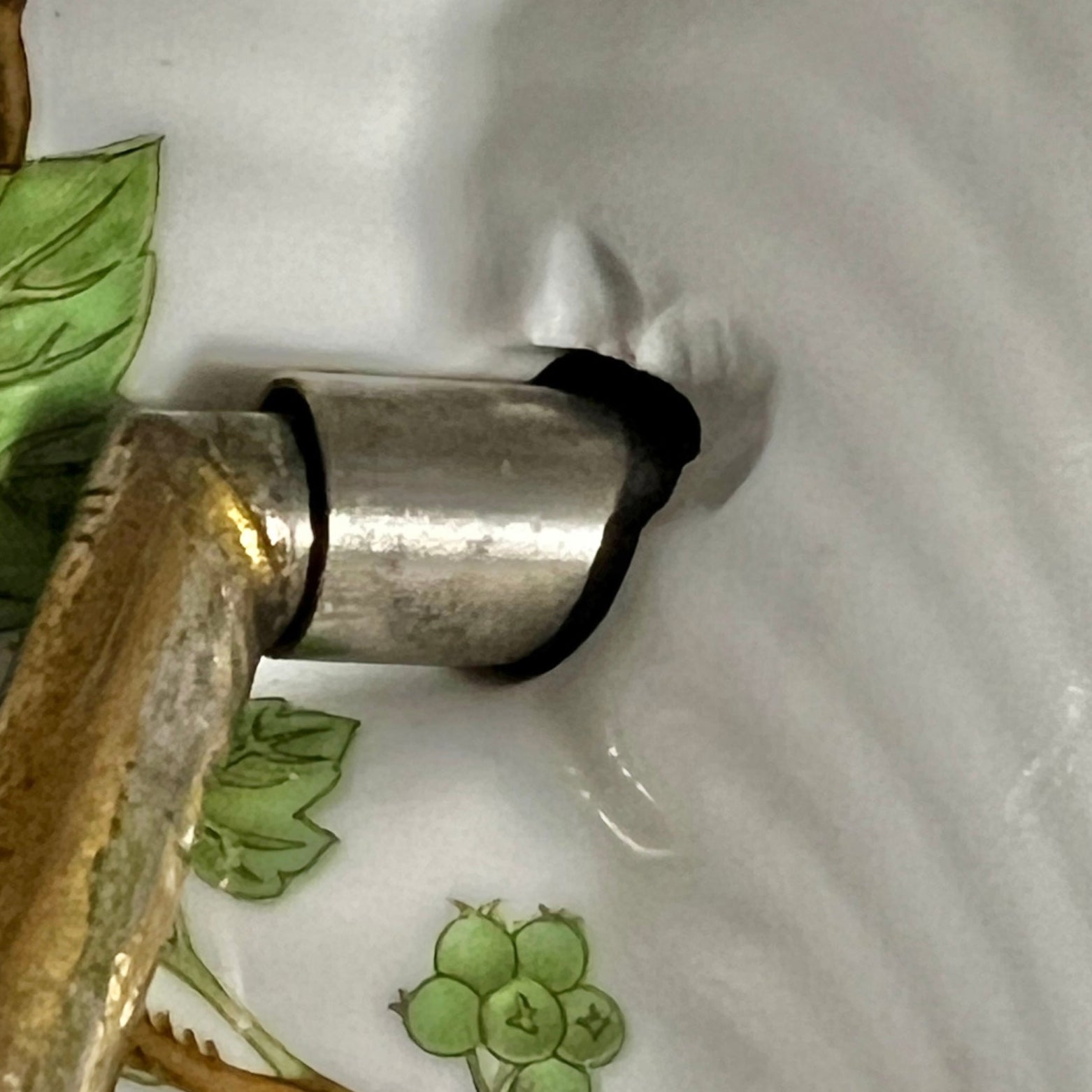 close up of towel hoop with leaf design on a white background