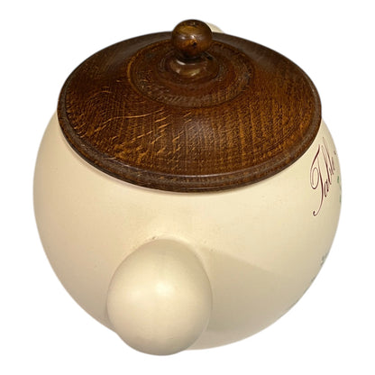 Round wooden object with a wooden brown top and smooth beige bottom on a white background