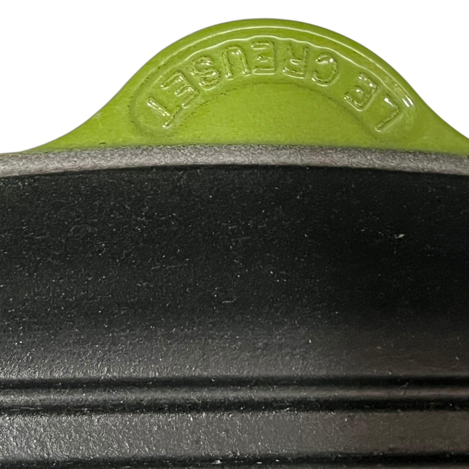 Close-up of a green and black iron skillet with 'Le Creuset' branding.