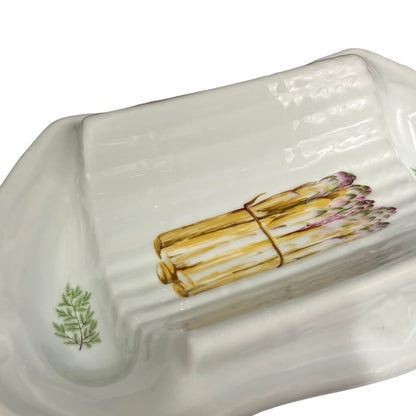 A white ceramic asparagus dish with a painted illustration of a bundle of asparagus tied with a string, set against a clean white background.